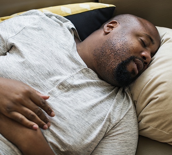 Man resting peacefully after sleep apnea therapy