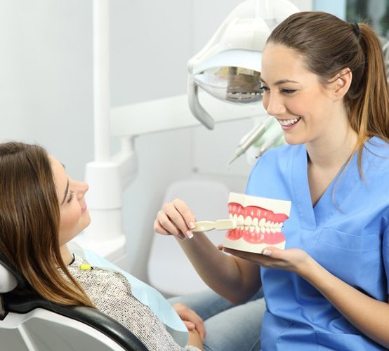Patient in Owasso smiling with hygienist at dental cleaning