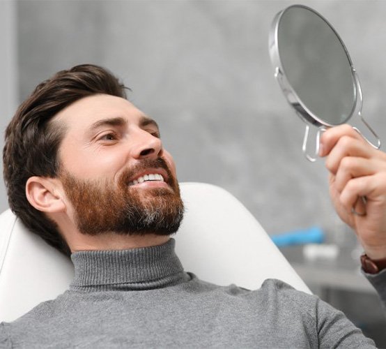 A patient checking his teeth with a mirror